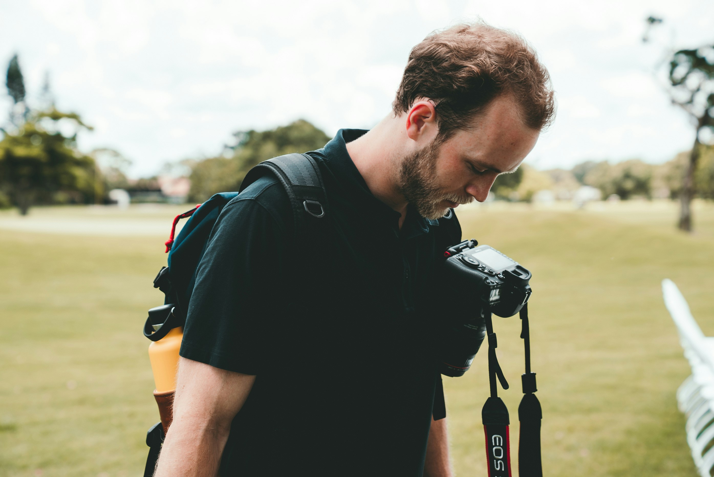 man in black t-shirt looking at his camera